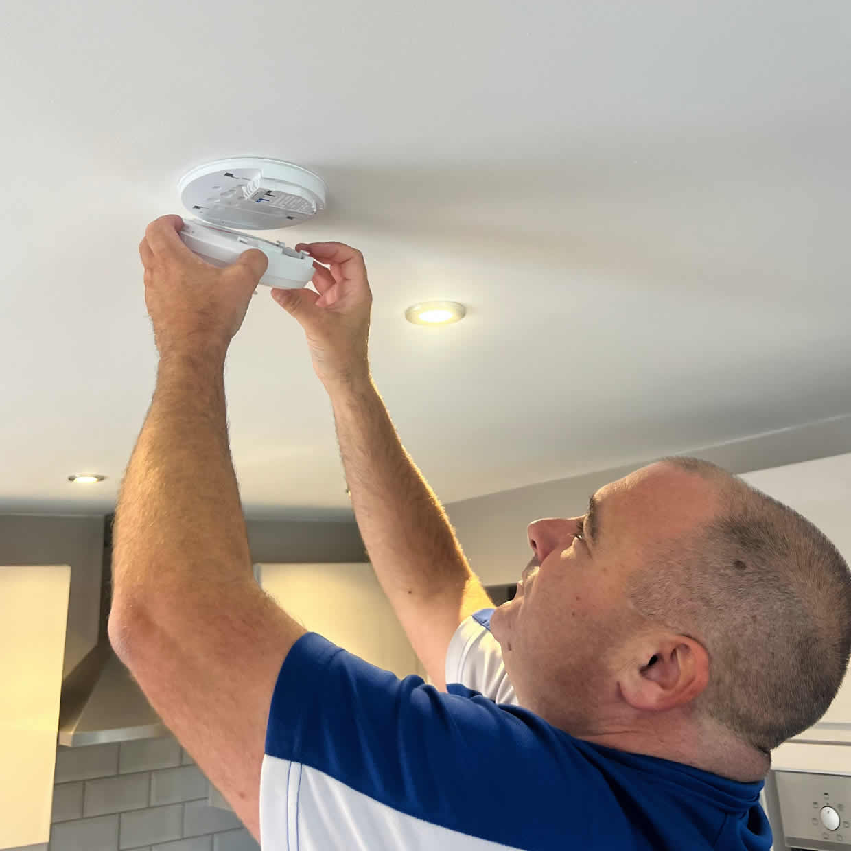 Smoke alarm being installed on a ceiling in Loughborough